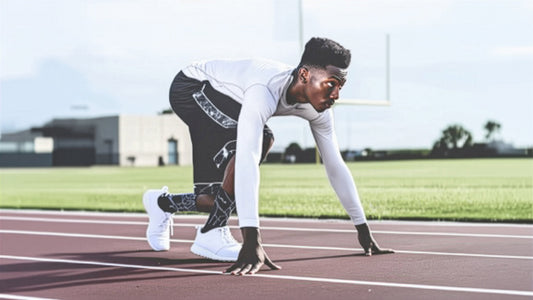 A determined athlete wearing Wear Grit performance apparel crouches at the starting line on a running track, ready to sprint | Motivational affirmation apparel for sports