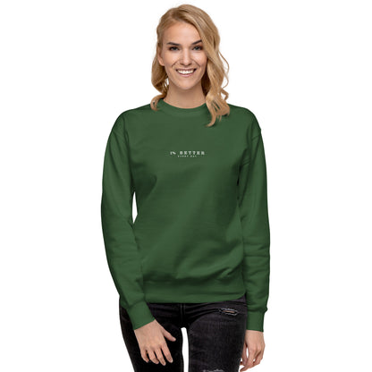 a female model with a green sweater with a print 1% Better Every Day — Motivational Grit Sweatshirt; mindset apparel for leaders and achievers focused on growth and discipline by wear grit brand clothing
