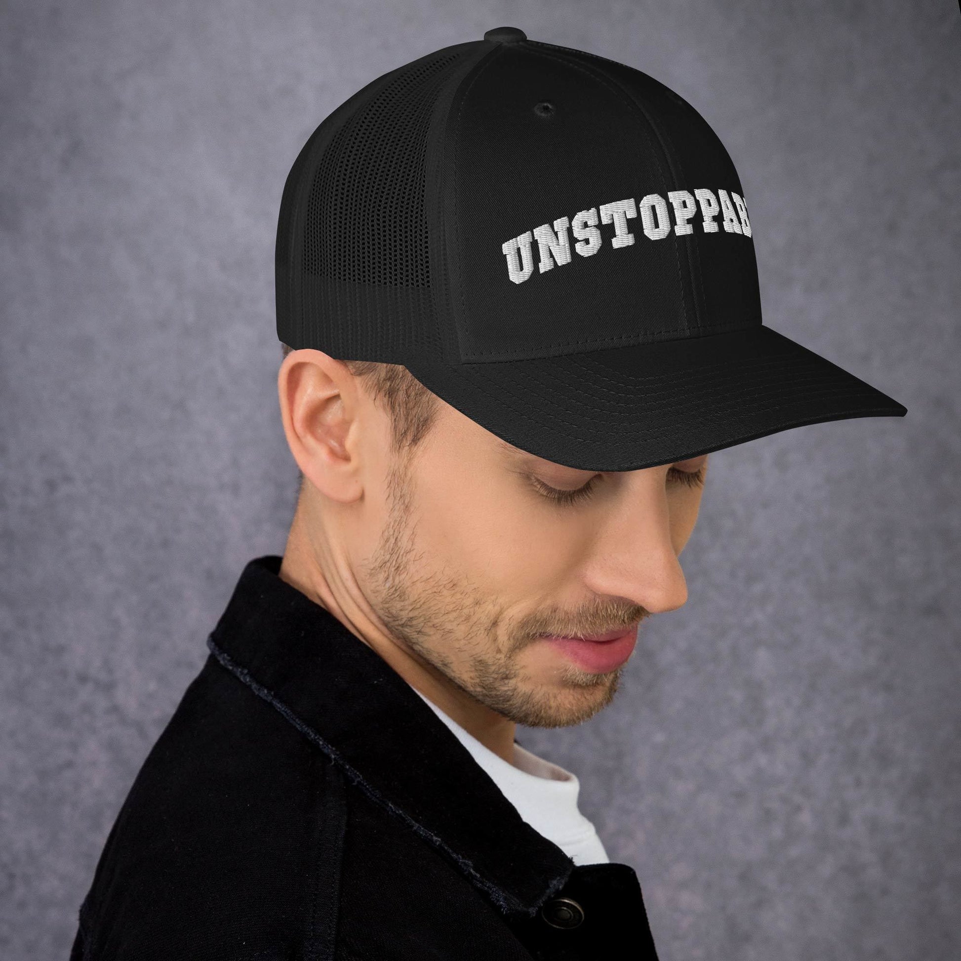 A man wearing black Unstoppable Trucker Hat mindset-driven by Wear Grit Brand Apparel – structured performance trucker hat for discipline, focus, and consistency
