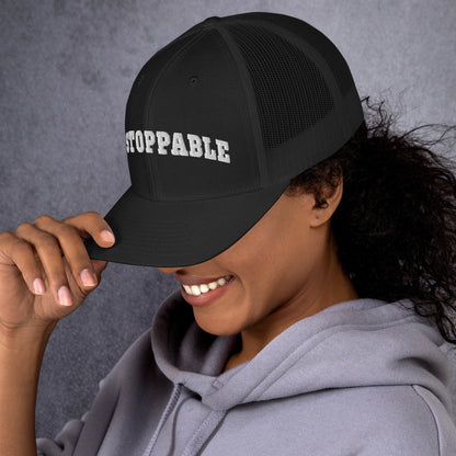 A woman wearing black Unstoppable Trucker Hat mindset-driven by Wear Grit Brand Apparel – structured performance trucker hat for discipline, focus, and consistency