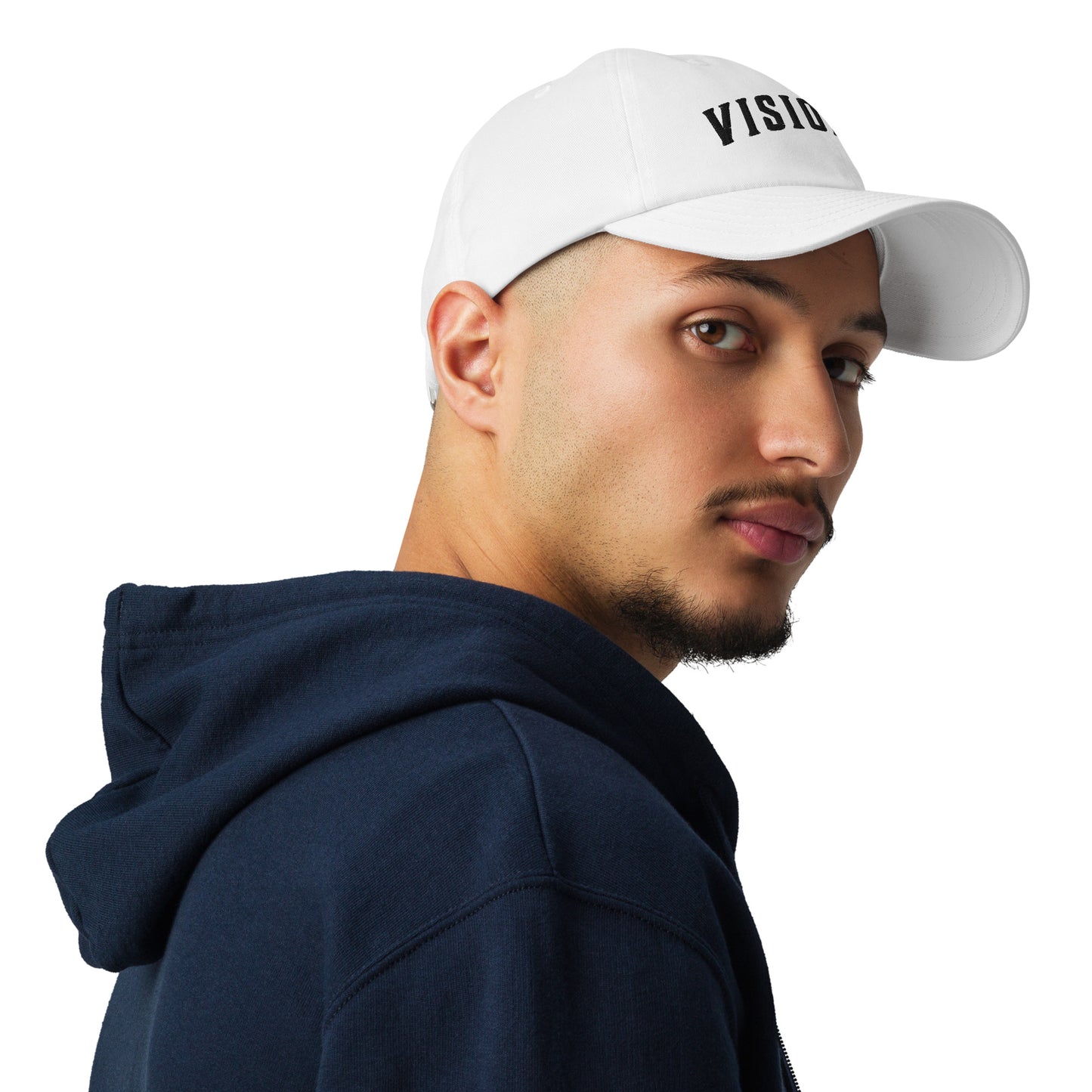 A photo of athlete wearing white Visionary Under Armour® dad hat with embroidered logo, low-profile unstructured design, curved visor, and adjustable strap for focused, clear, and long-term disciplined everyday grind, product by Wear Grit Brand Clothing