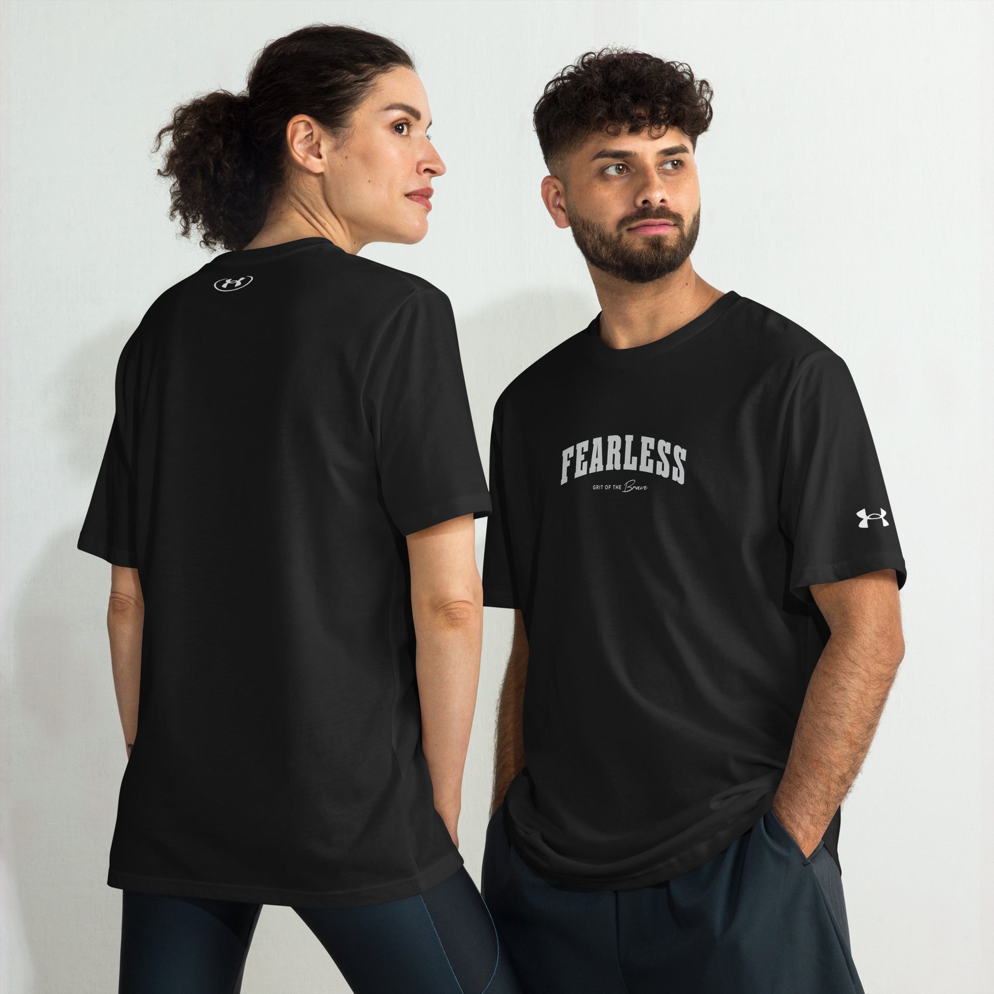 a models wearing black Fearless Under ArmourⓇ fitness t-shirt for training and workouts with relaxed fit and split hem