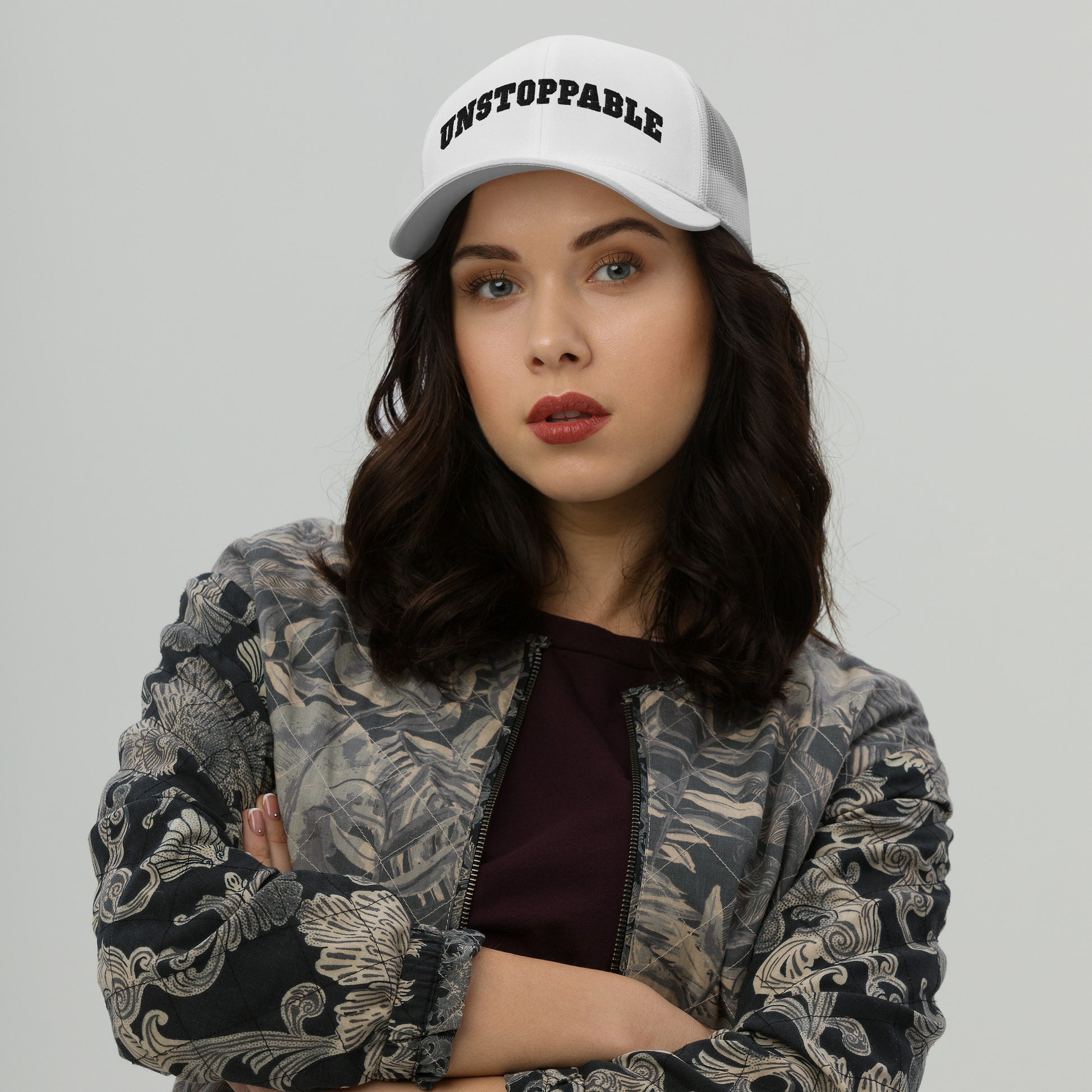 A woman wearing white Unstoppable Trucker Hat mindset-driven by Wear Grit Brand Apparel – structured performance trucker hat for discipline, focus, and consistency
